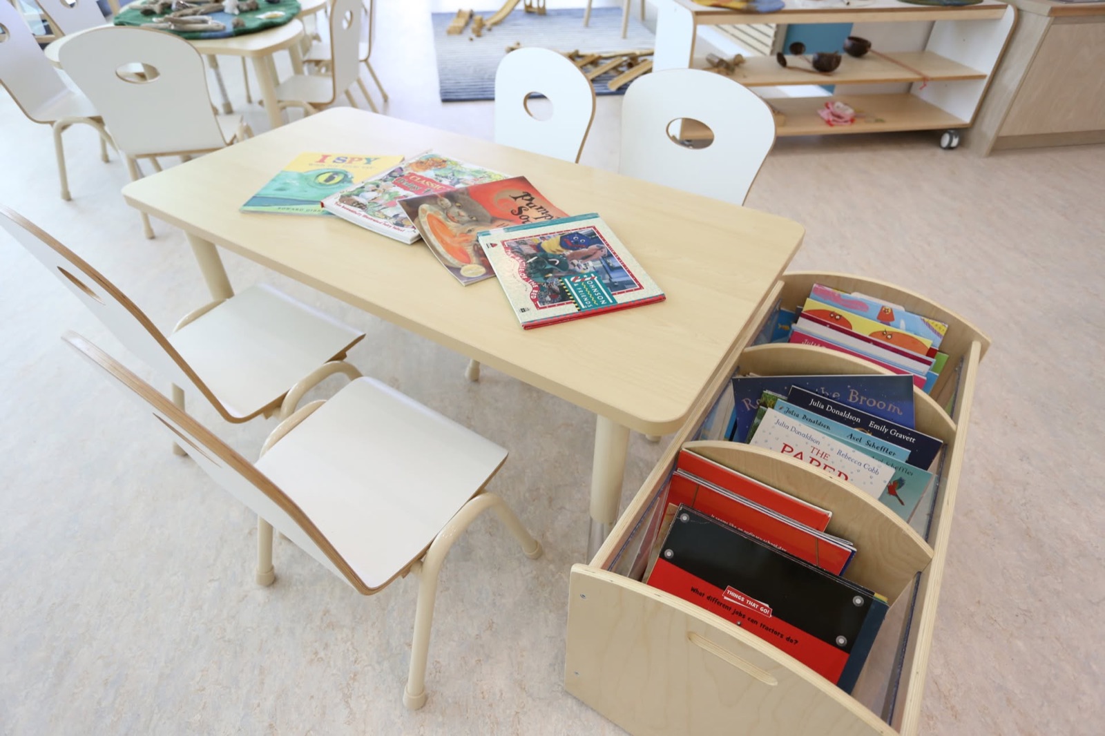A reading table with picture books and a low book trolley