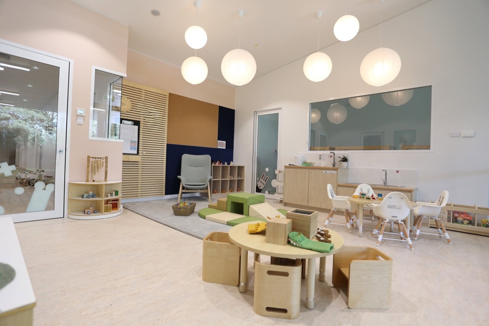 A bright playroom with low tables and soft lighting